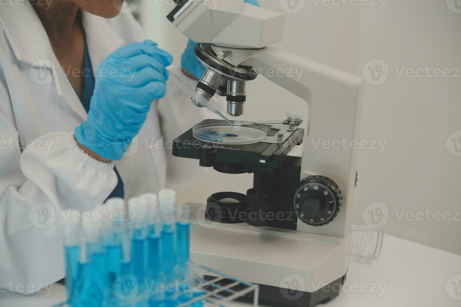 Health care researchers working in life science laboratory. Young female research scientist and senior male supervisor preparing and analyzing microscope slides in research lab. photo