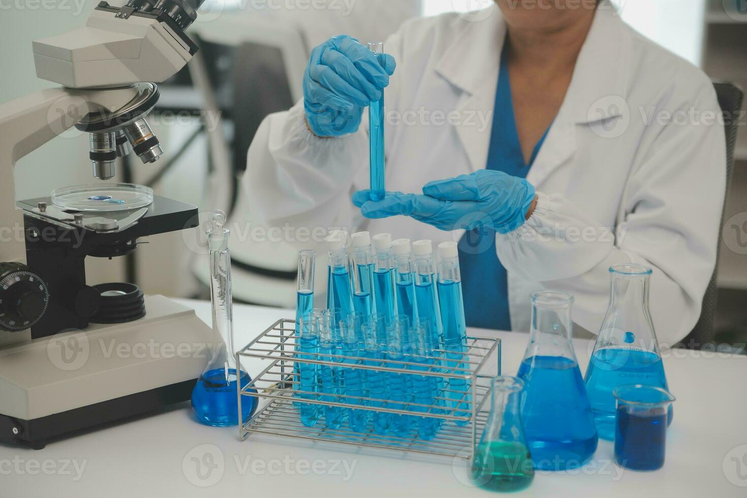 Health care researchers working in life science laboratory. Young female research scientist and senior male supervisor preparing and analyzing microscope slides in research lab. photo
