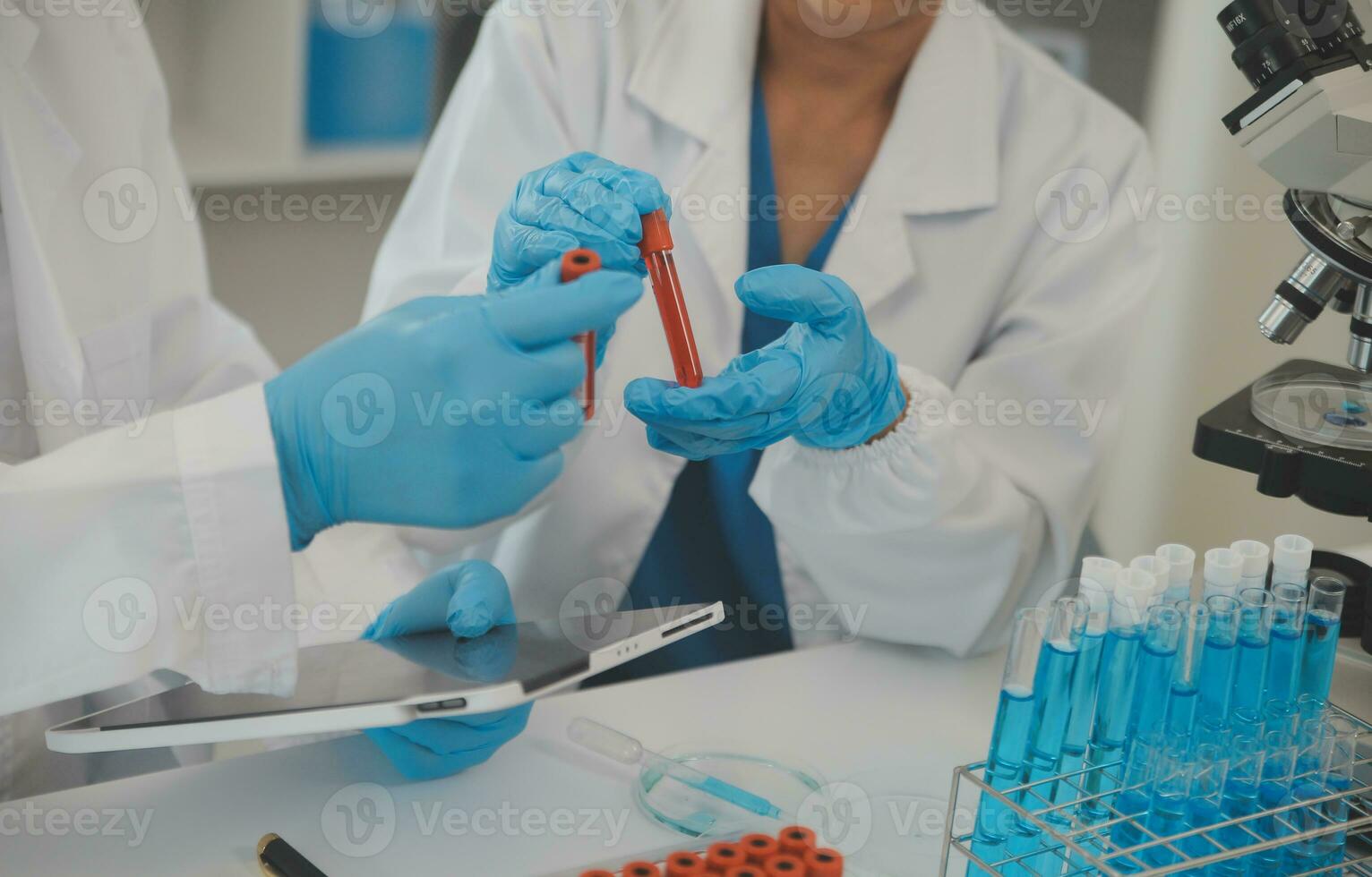 Health care researchers working in life science laboratory. Young female research scientist and senior male supervisor preparing and analyzing microscope slides in research lab. photo
