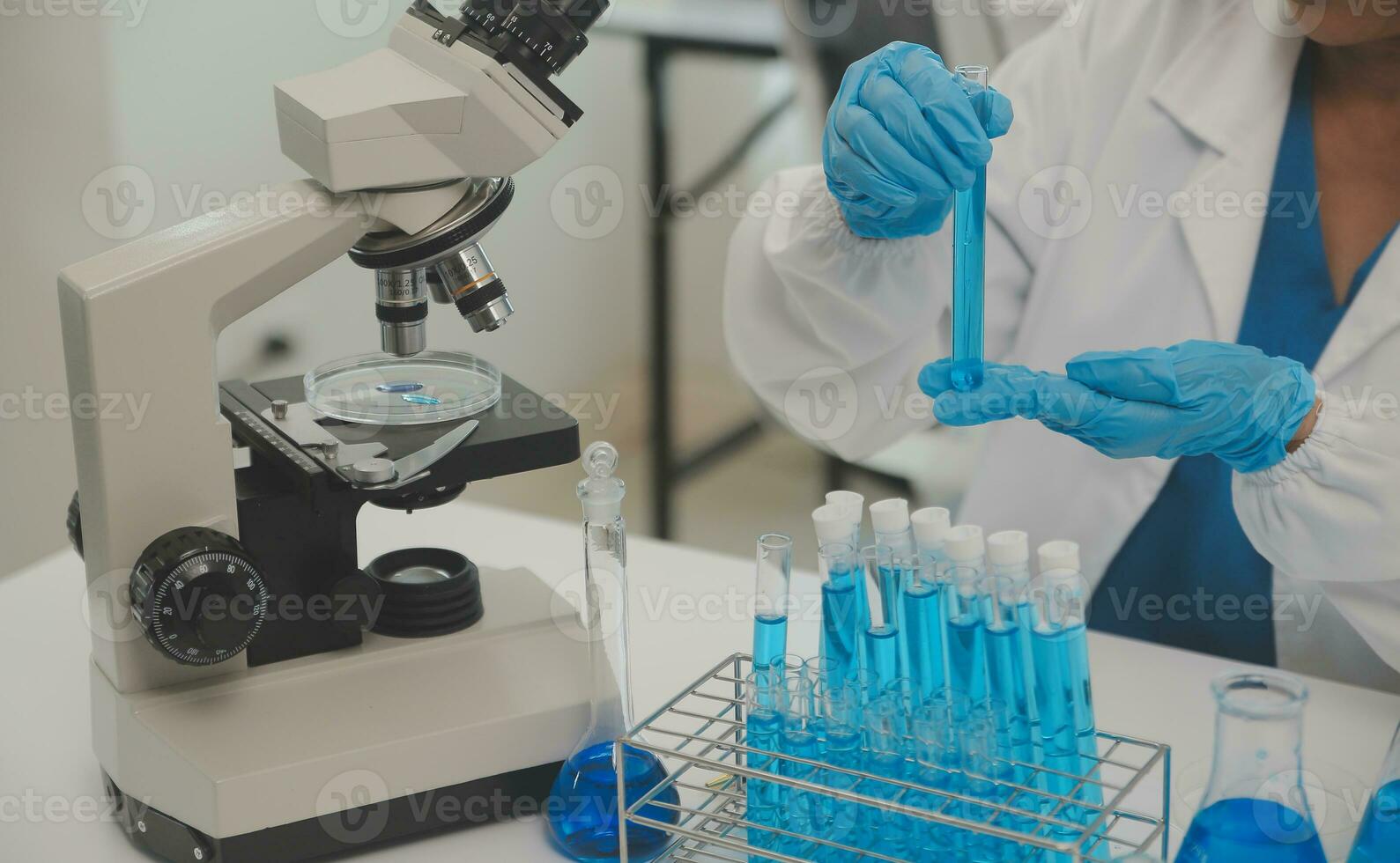 Health care researchers working in life science laboratory. Young female research scientist and senior male supervisor preparing and analyzing microscope slides in research lab. photo