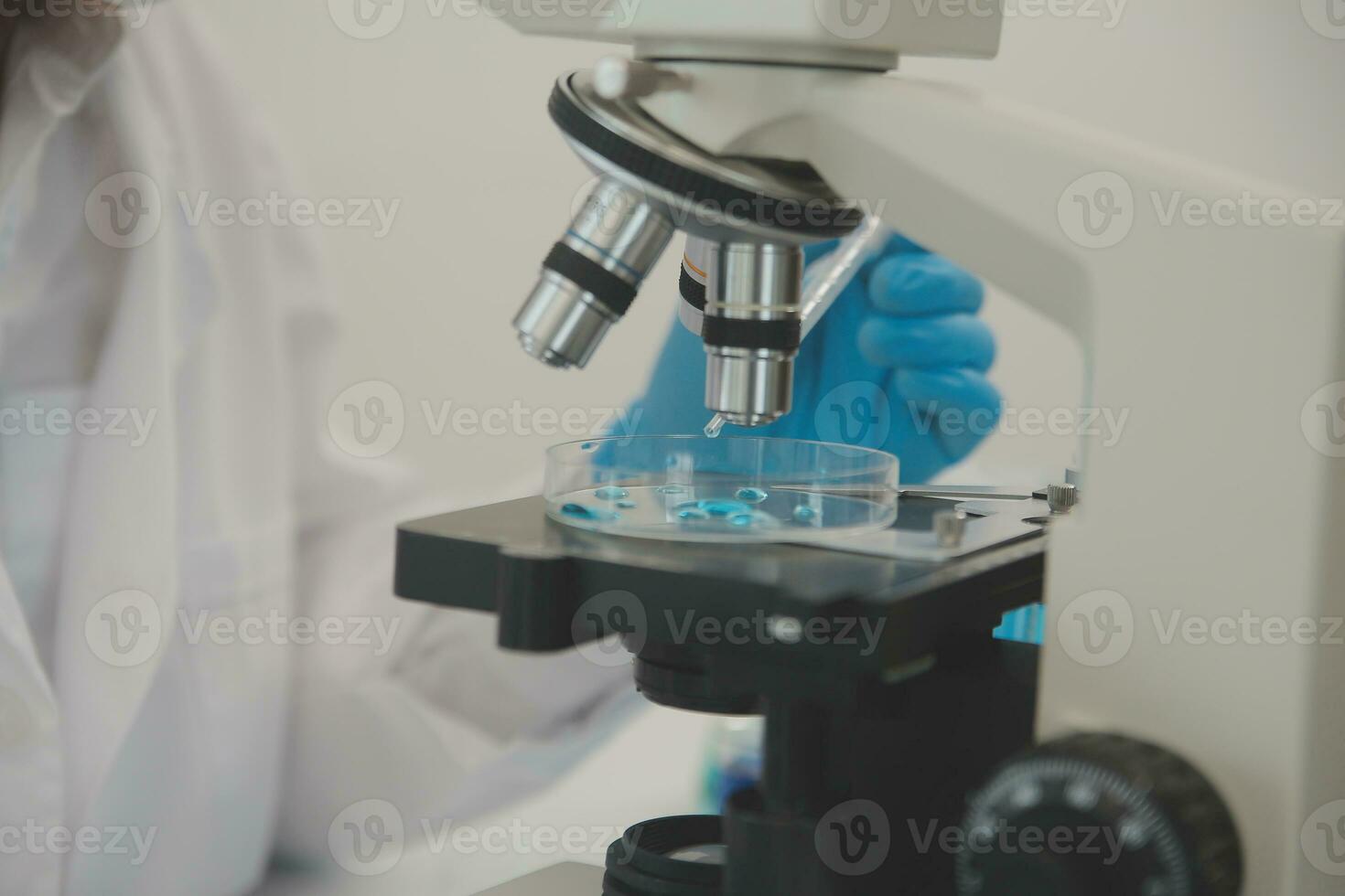 Health care researchers working in life science laboratory. Young female research scientist and senior male supervisor preparing and analyzing microscope slides in research lab. photo