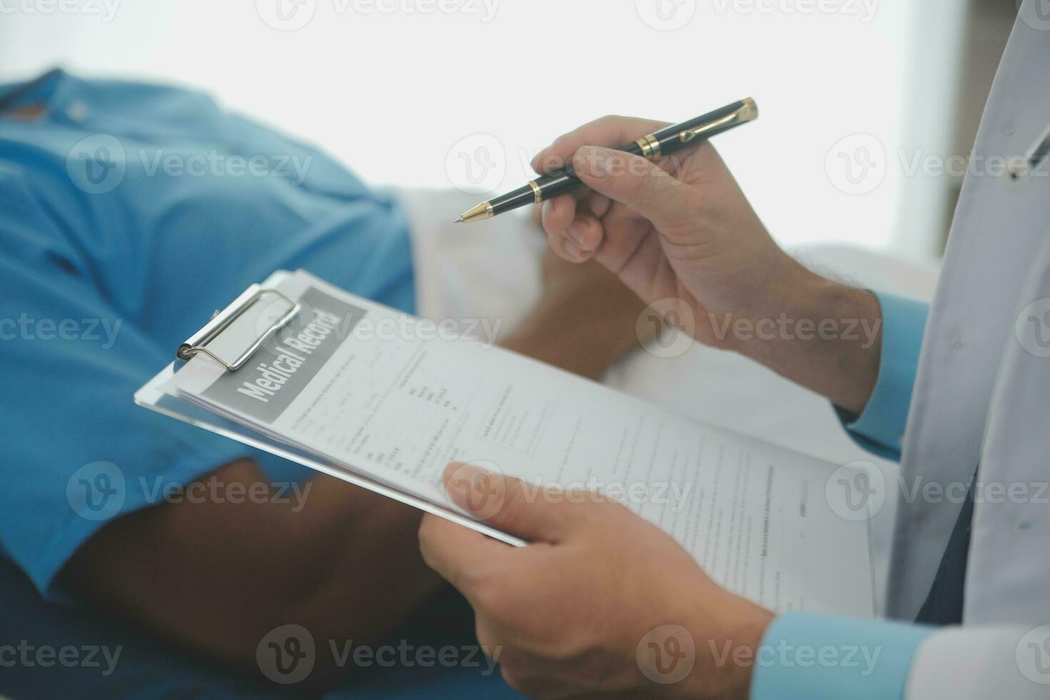 Close up of doctor sitting on bedside of male patient in hospital photo