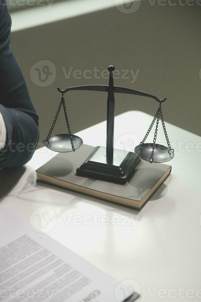 Business and lawyers discussing contract papers with brass scale on desk in office. Law, legal services, advice, justice and law concept picture with film grain effect photo