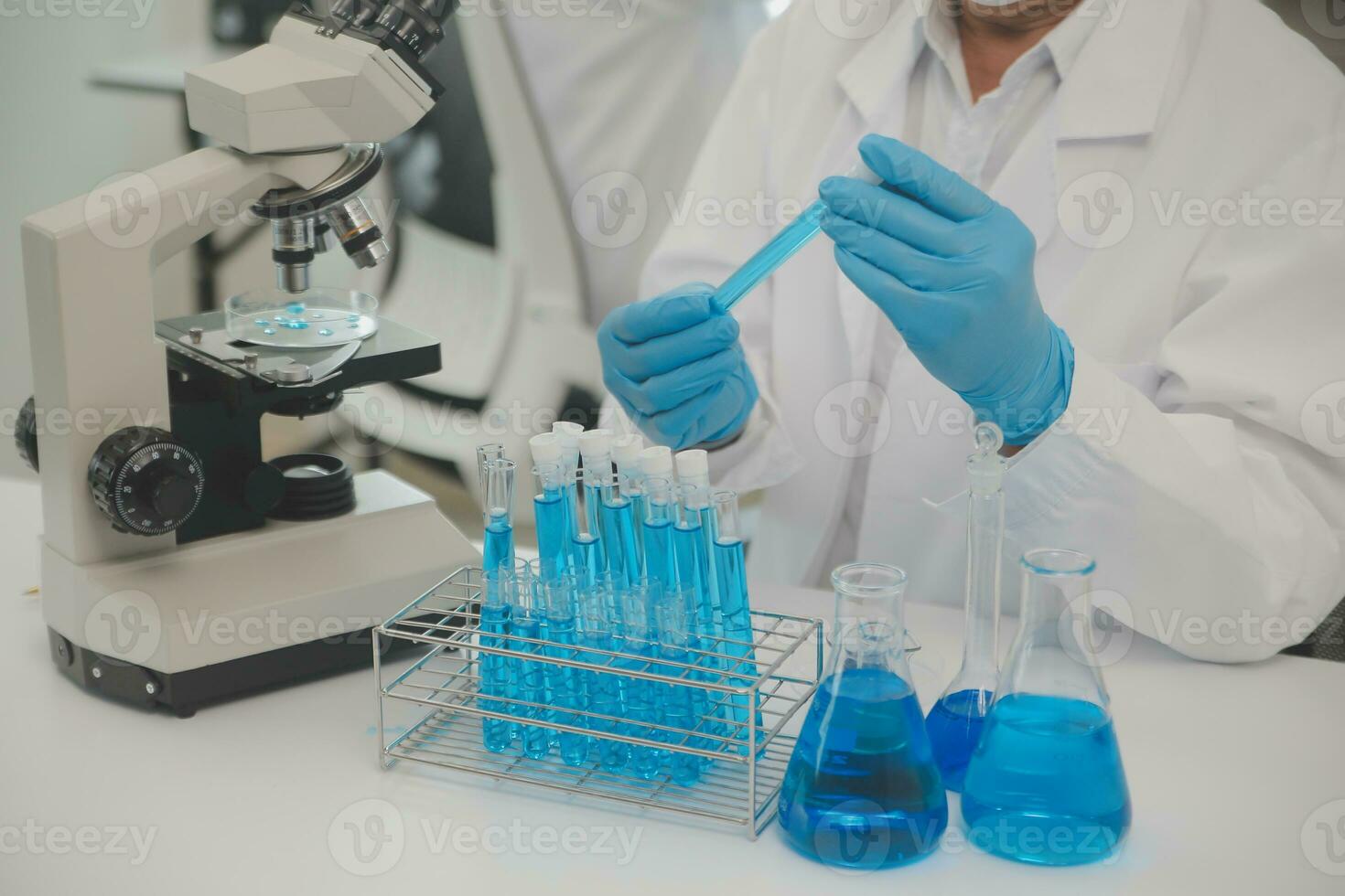 Health care researchers working in life science laboratory. Young female research scientist and senior male supervisor preparing and analyzing microscope slides in research lab. photo