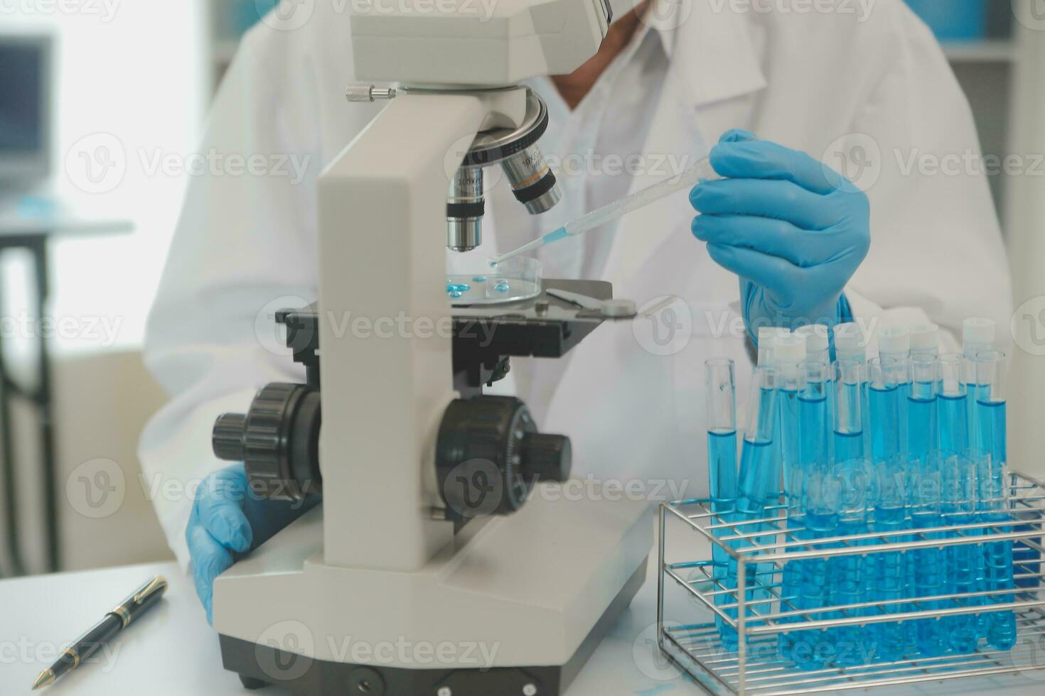 Health care researchers working in life science laboratory. Young female research scientist and senior male supervisor preparing and analyzing microscope slides in research lab. photo