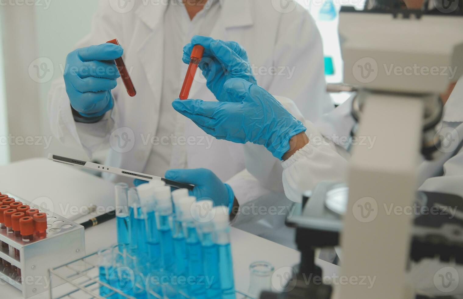 Health care researchers working in life science laboratory. Young female research scientist and senior male supervisor preparing and analyzing microscope slides in research lab. photo