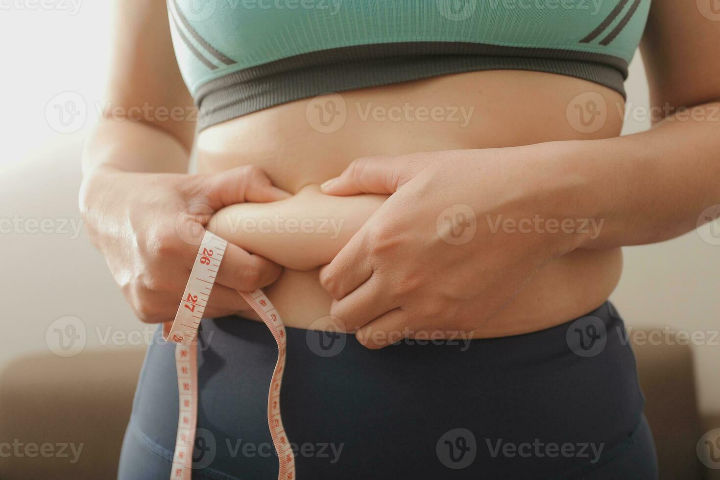 Women body fat belly. Obese woman hand holding excessive belly fat. diet lifestyle concept to reduce belly and shape up healthy stomach muscle. photo