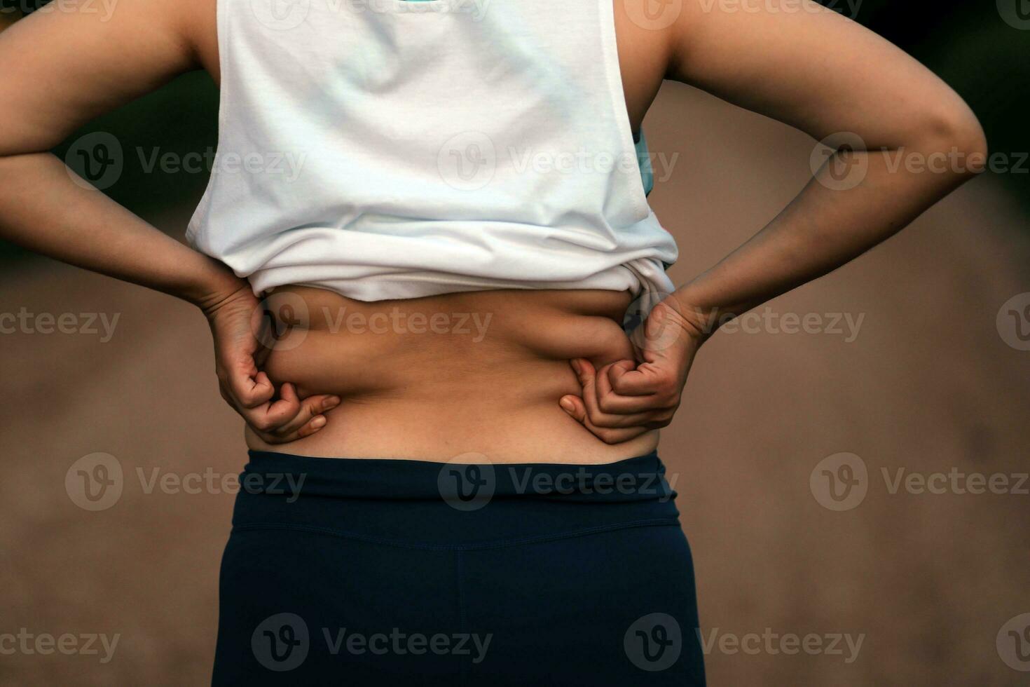 Women body fat belly. Obese woman hand holding excessive belly fat. diet lifestyle concept to reduce belly and shape up healthy stomach muscle. photo