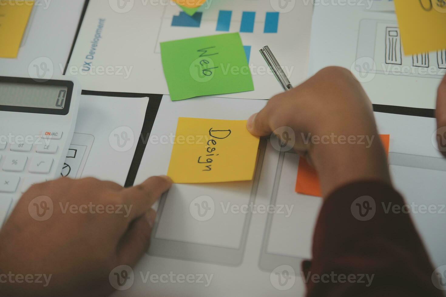 Close up ux developer and ui designer brainstorming about mobile app interface wireframe design on table with customer breif and color code at modern office.Creative digital development agency photo