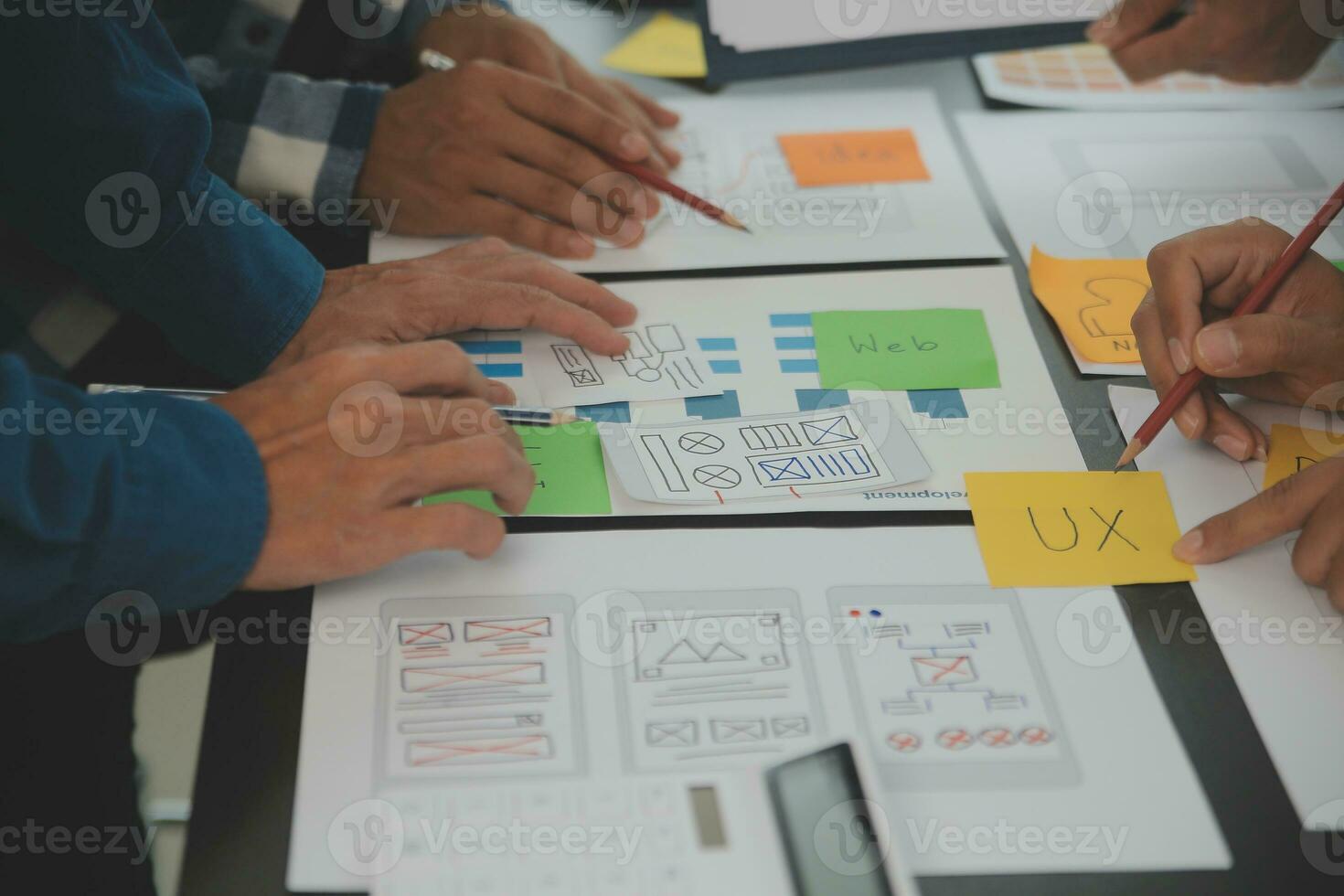 Close up ux developer and ui designer brainstorming about mobile app interface wireframe design on table with customer breif and color code at modern office.Creative digital development agency photo