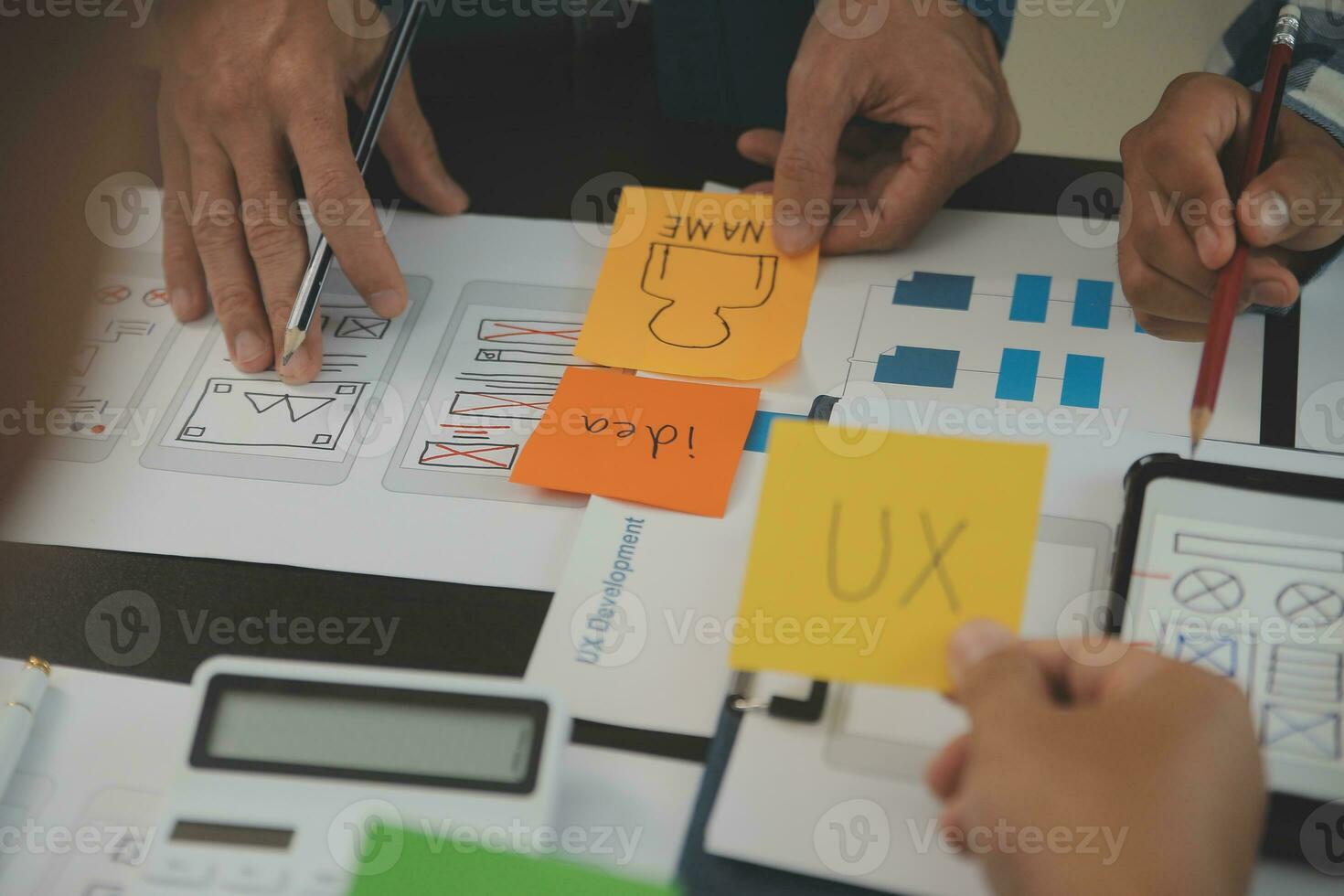 Close up ux developer and ui designer brainstorming about mobile app interface wireframe design on table with customer breif and color code at modern office.Creative digital development agency photo