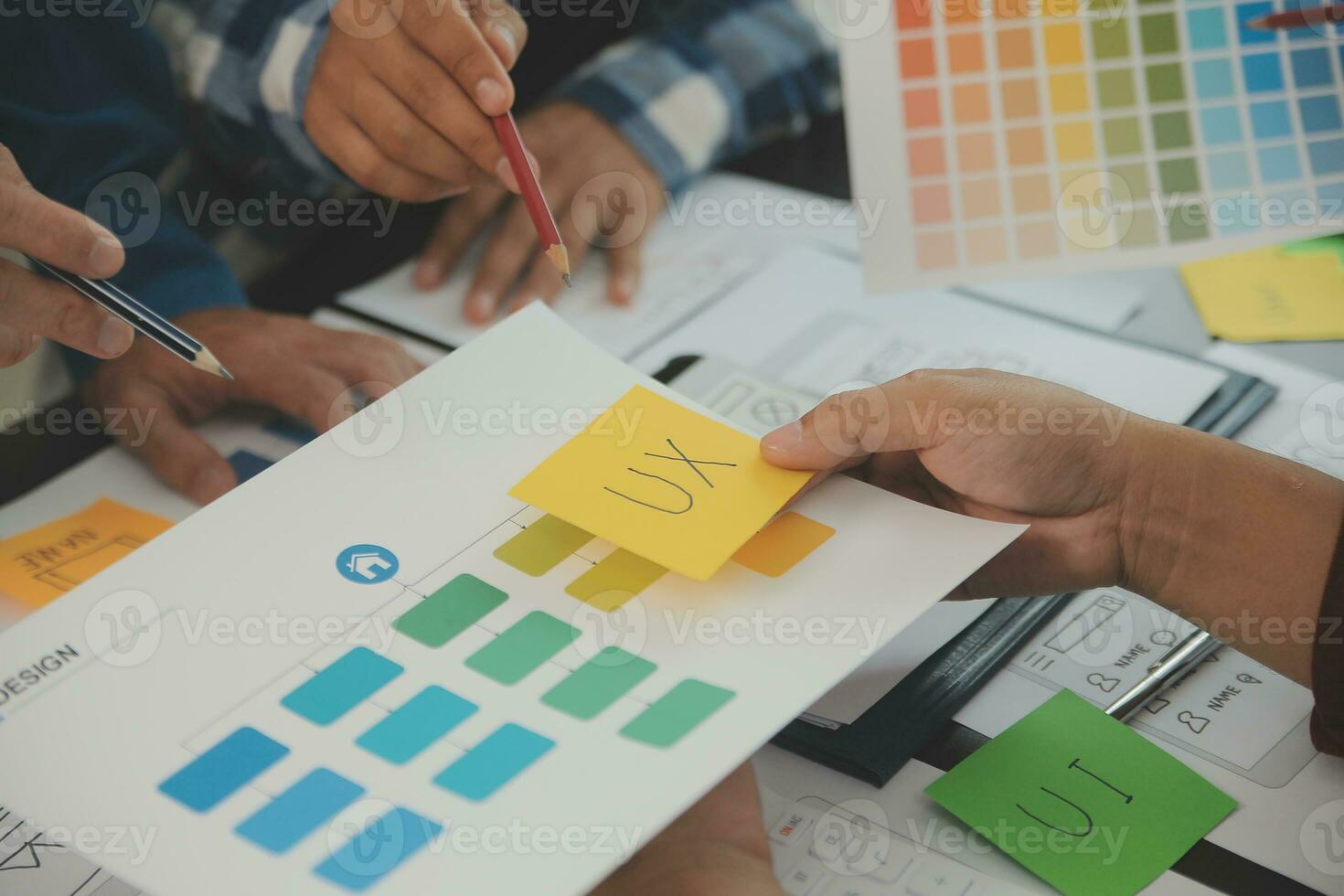 Close up ux developer and ui designer brainstorming about mobile app interface wireframe design on table with customer breif and color code at modern office.Creative digital development agency photo