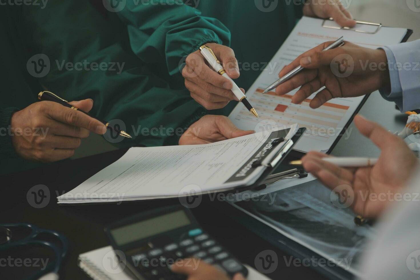 Group of doctors reading a document in meeting room at hospital photo