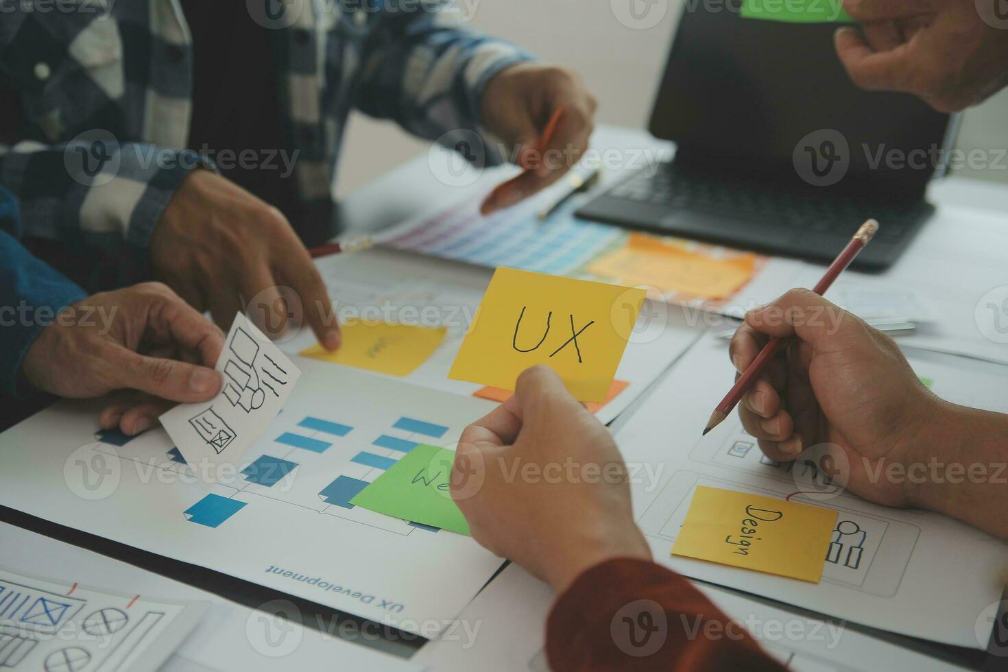 Close up ux developer and ui designer brainstorming about mobile app interface wireframe design on table with customer breif and color code at modern office.Creative digital development agency photo