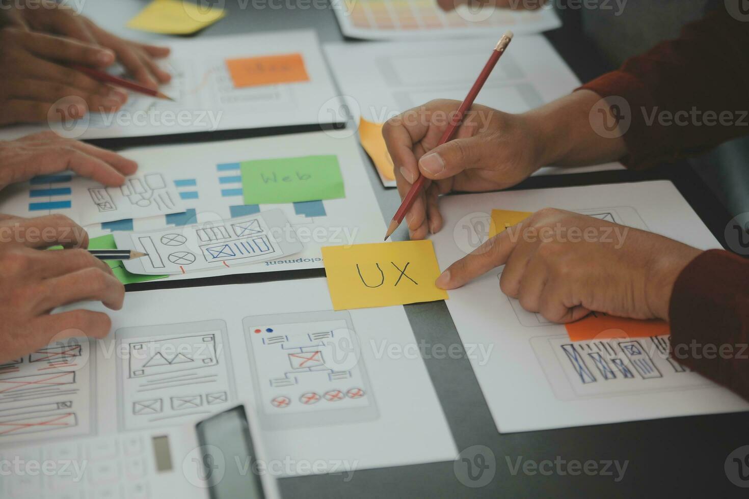 Close up ux developer and ui designer brainstorming about mobile app interface wireframe design on table with customer breif and color code at modern office.Creative digital development agency photo