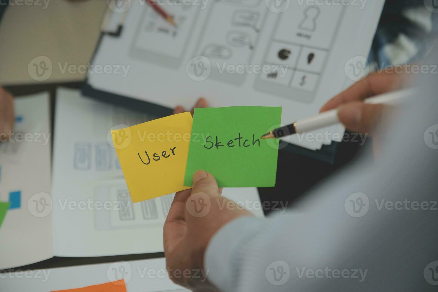 Close up ux developer and ui designer brainstorming about mobile app interface wireframe design on table with customer breif and color code at modern office.Creative digital development agency photo
