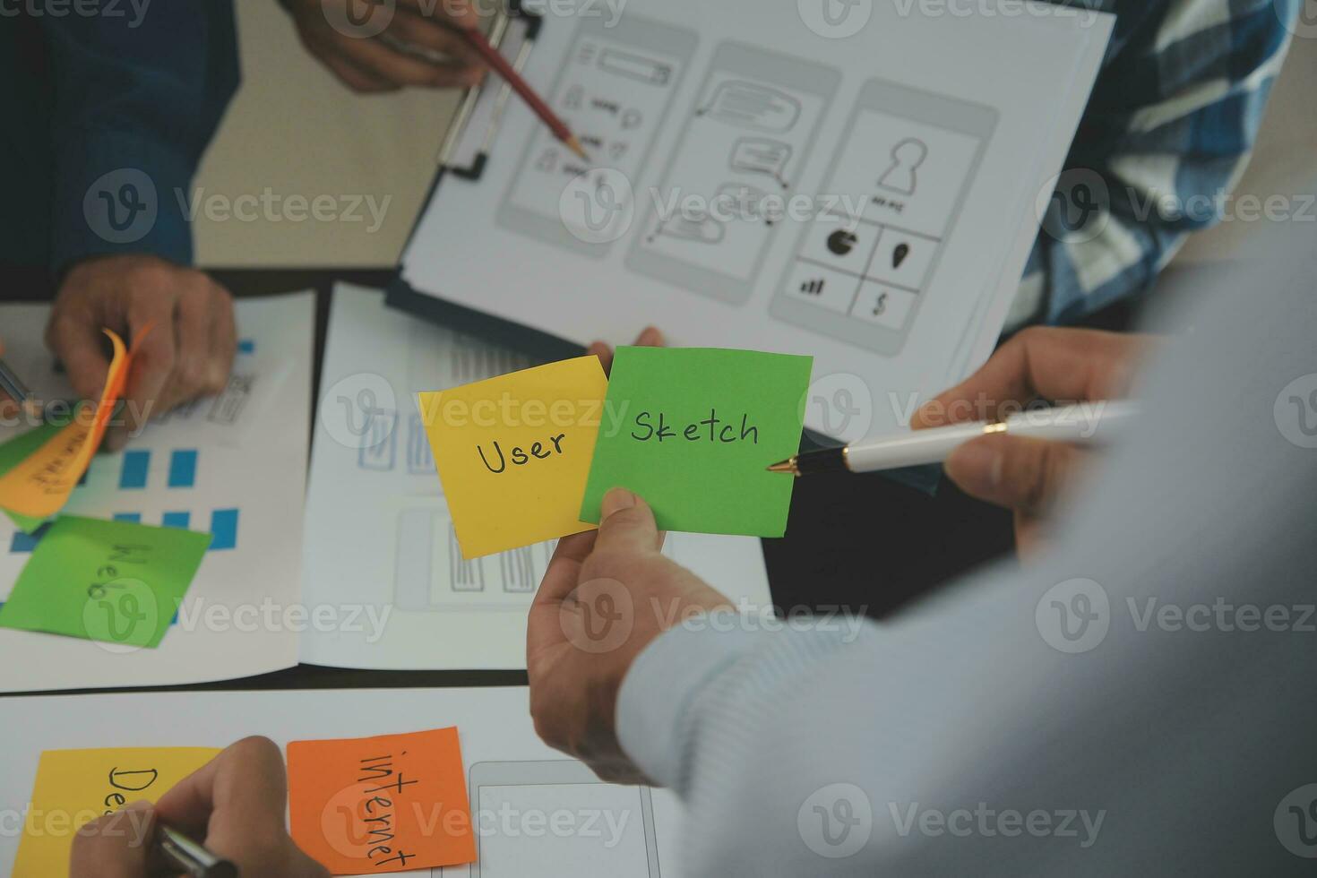 Close up ux developer and ui designer brainstorming about mobile app interface wireframe design on table with customer breif and color code at modern office.Creative digital development agency photo