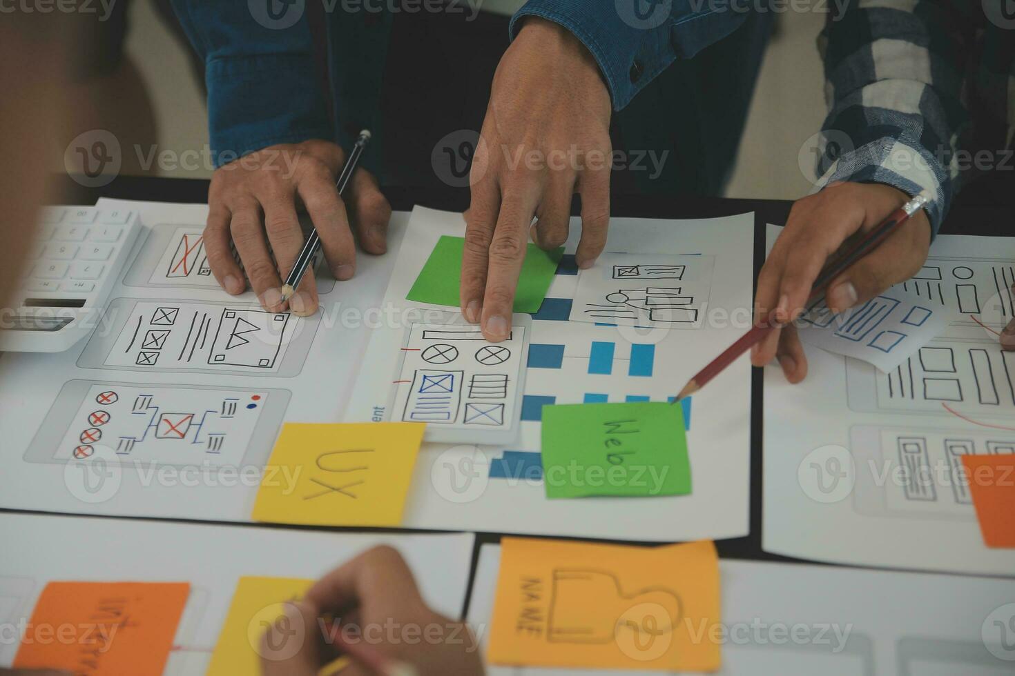 Close up ux developer and ui designer brainstorming about mobile app interface wireframe design on table with customer breif and color code at modern office.Creative digital development agency photo