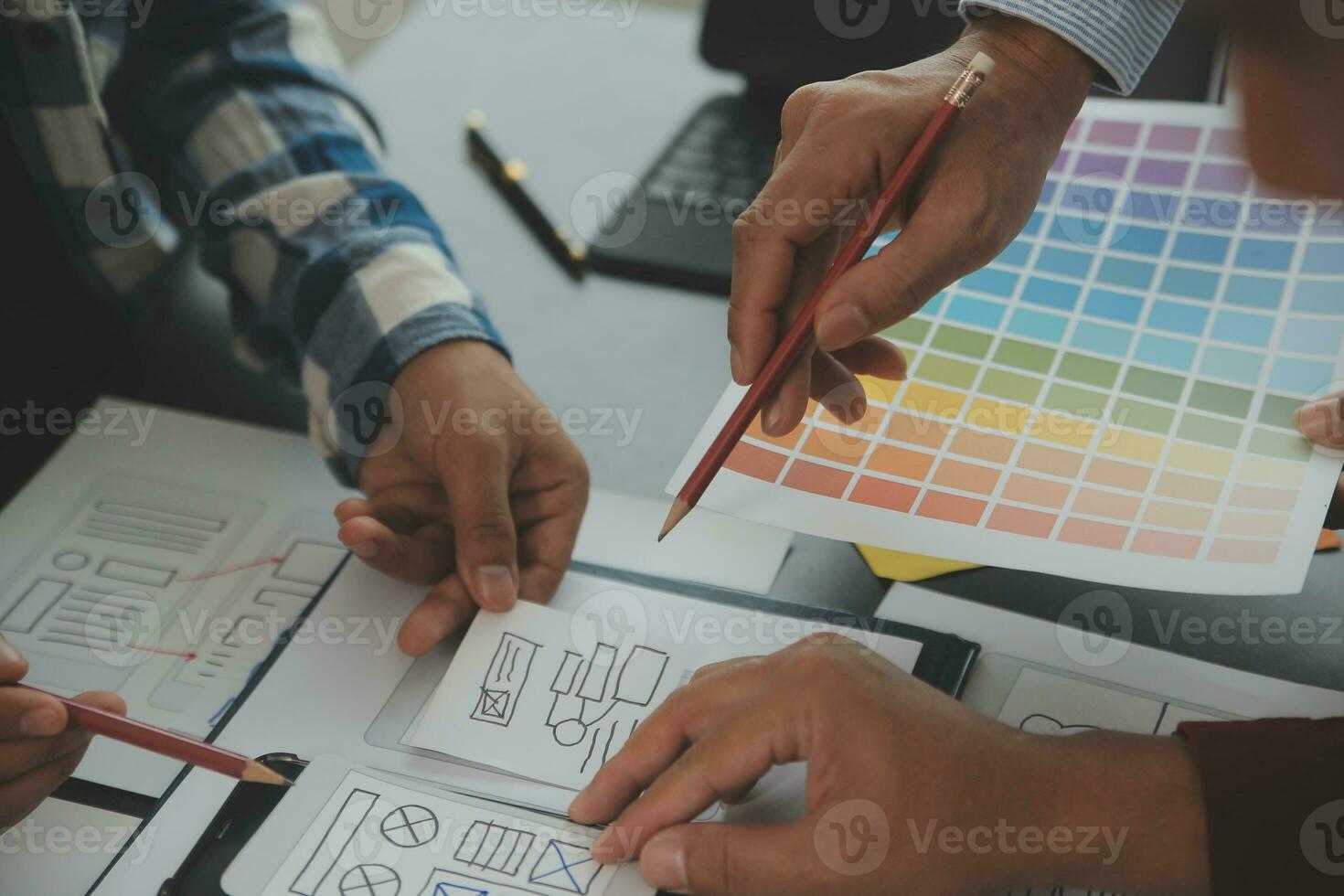 Close up ux developer and ui designer brainstorming about mobile app interface wireframe design on table with customer breif and color code at modern office.Creative digital development agency photo