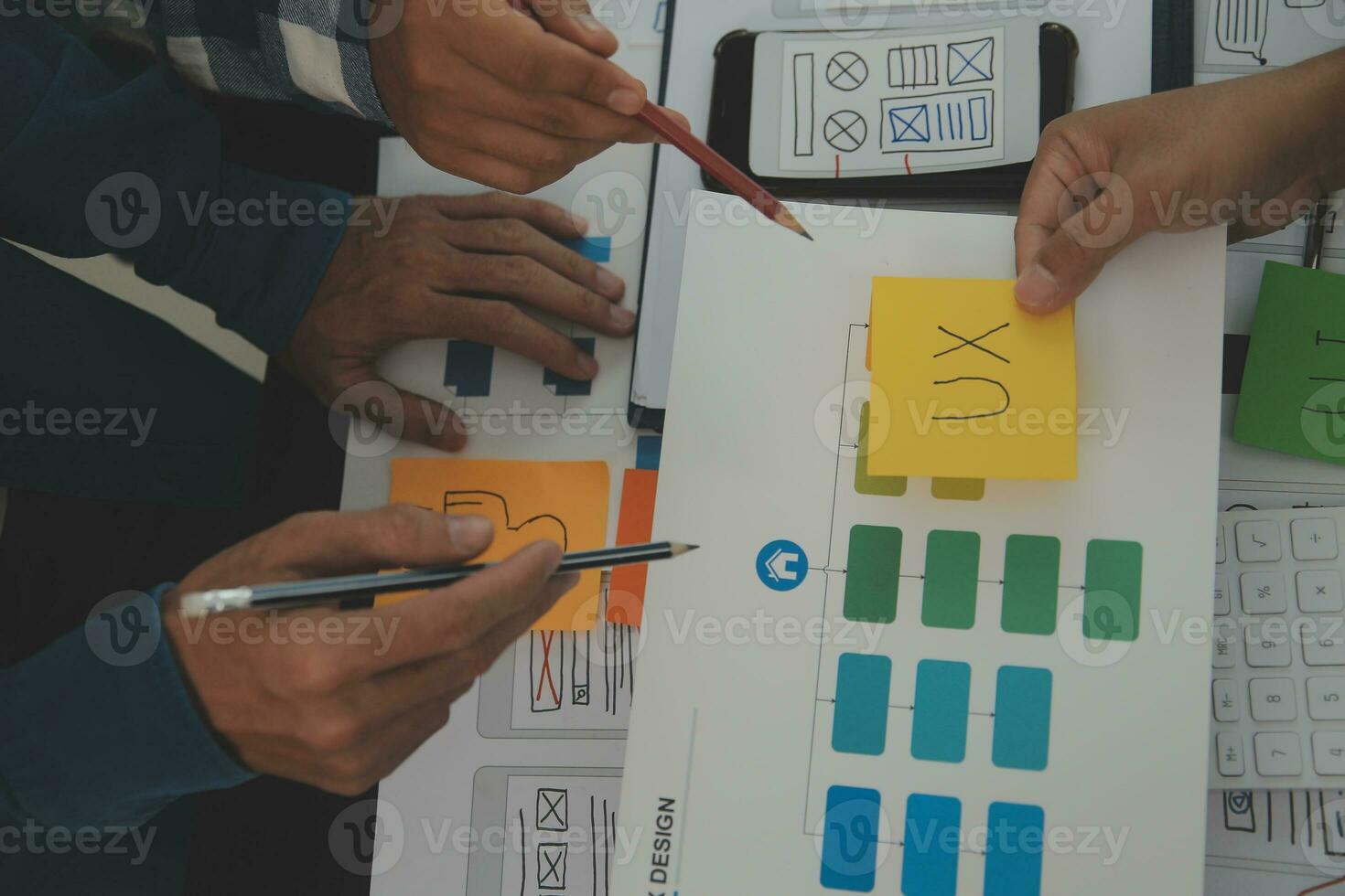 Close up ux developer and ui designer brainstorming about mobile app interface wireframe design on table with customer breif and color code at modern office.Creative digital development agency photo