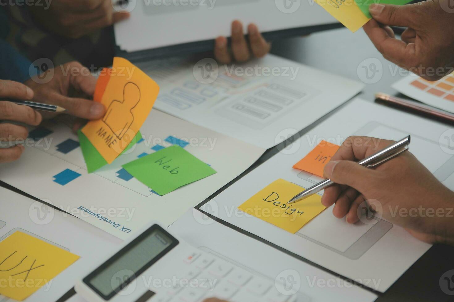Close up ux developer and ui designer brainstorming about mobile app interface wireframe design on table with customer breif and color code at modern office.Creative digital development agency photo