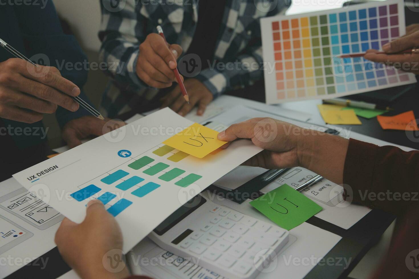 Close up ux developer and ui designer brainstorming about mobile app interface wireframe design on table with customer breif and color code at modern office.Creative digital development agency photo
