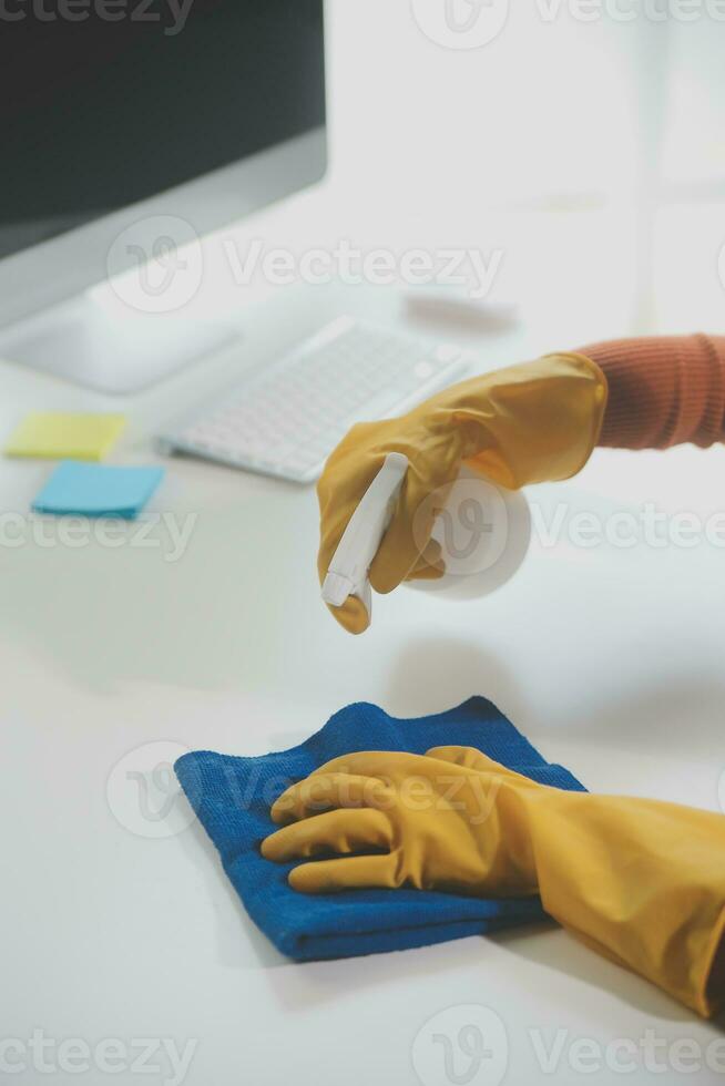Office Cleaning Service. Janitor Spraying Desk. Workplace Hygiene photo