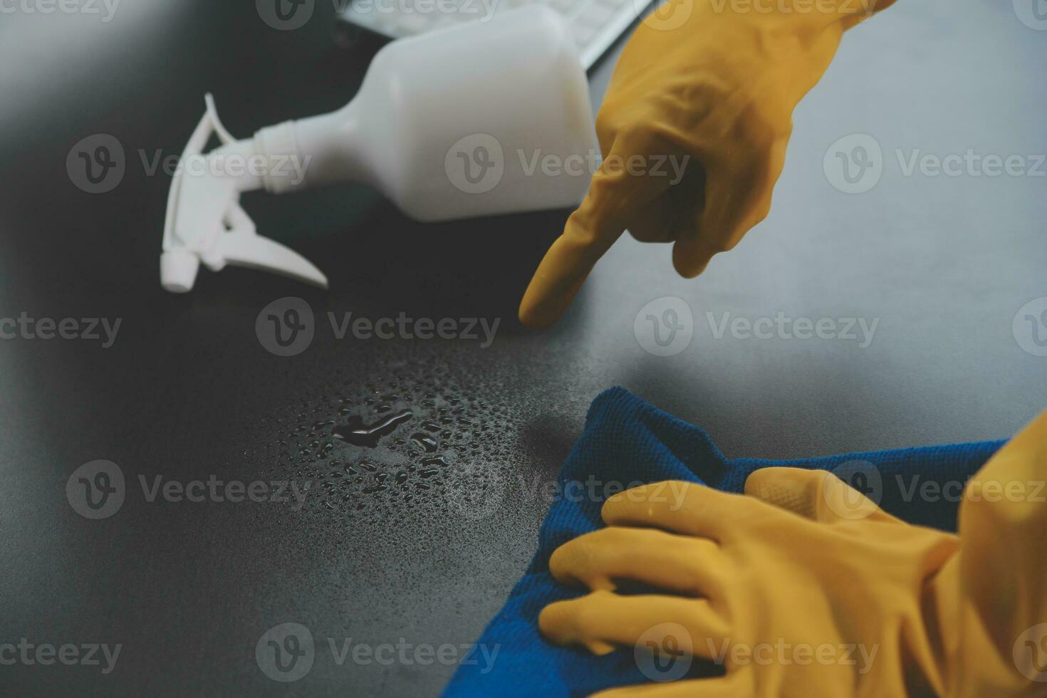 Office Cleaning Service. Janitor Spraying Desk. Workplace Hygiene photo