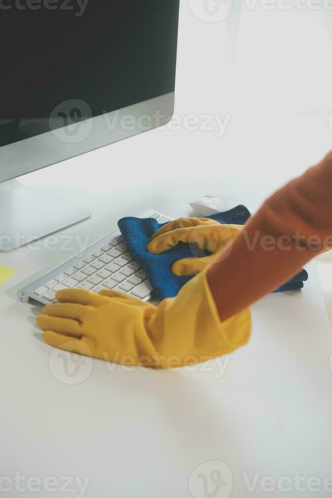 Office Cleaning Service. Janitor Spraying Desk. Workplace Hygiene photo