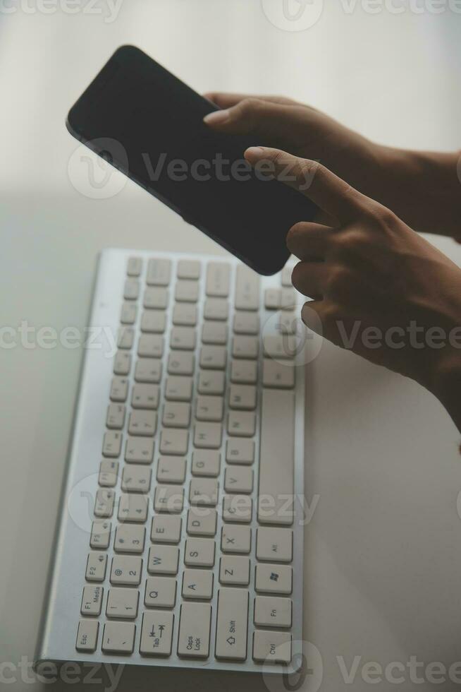 Asian Businesswoman Using laptop computer and working at office with calculator document on desk, doing planning analyzing the financial report, business plan investment, finance analysis concept. photo