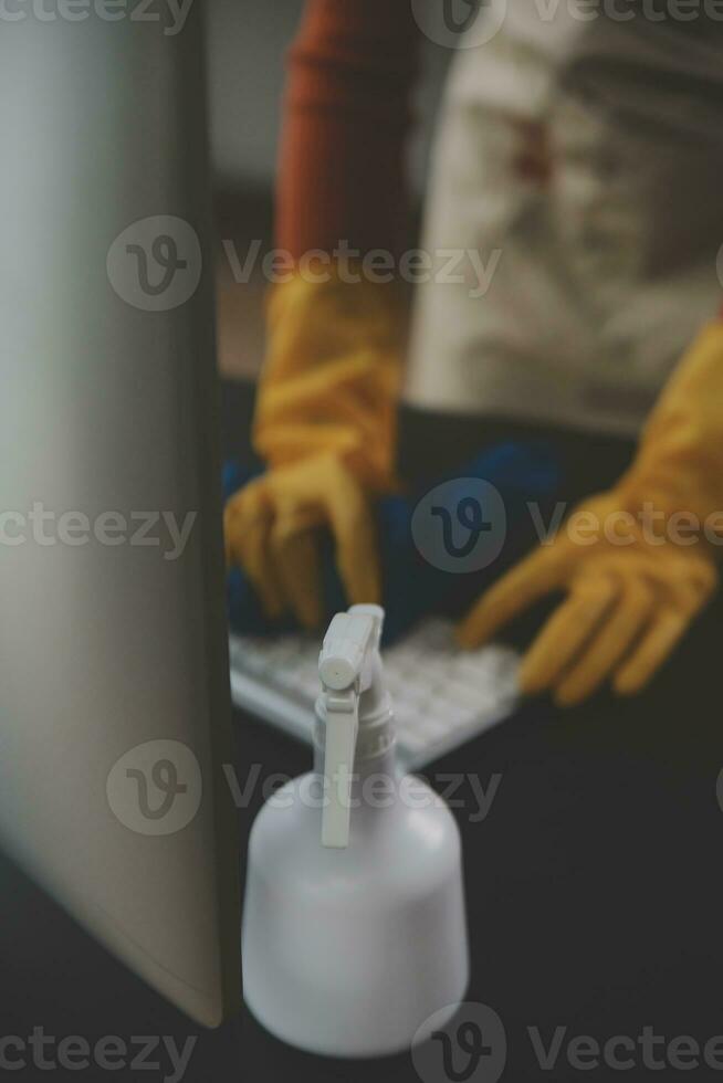 Office Cleaning Service. Janitor Spraying Desk. Workplace Hygiene photo