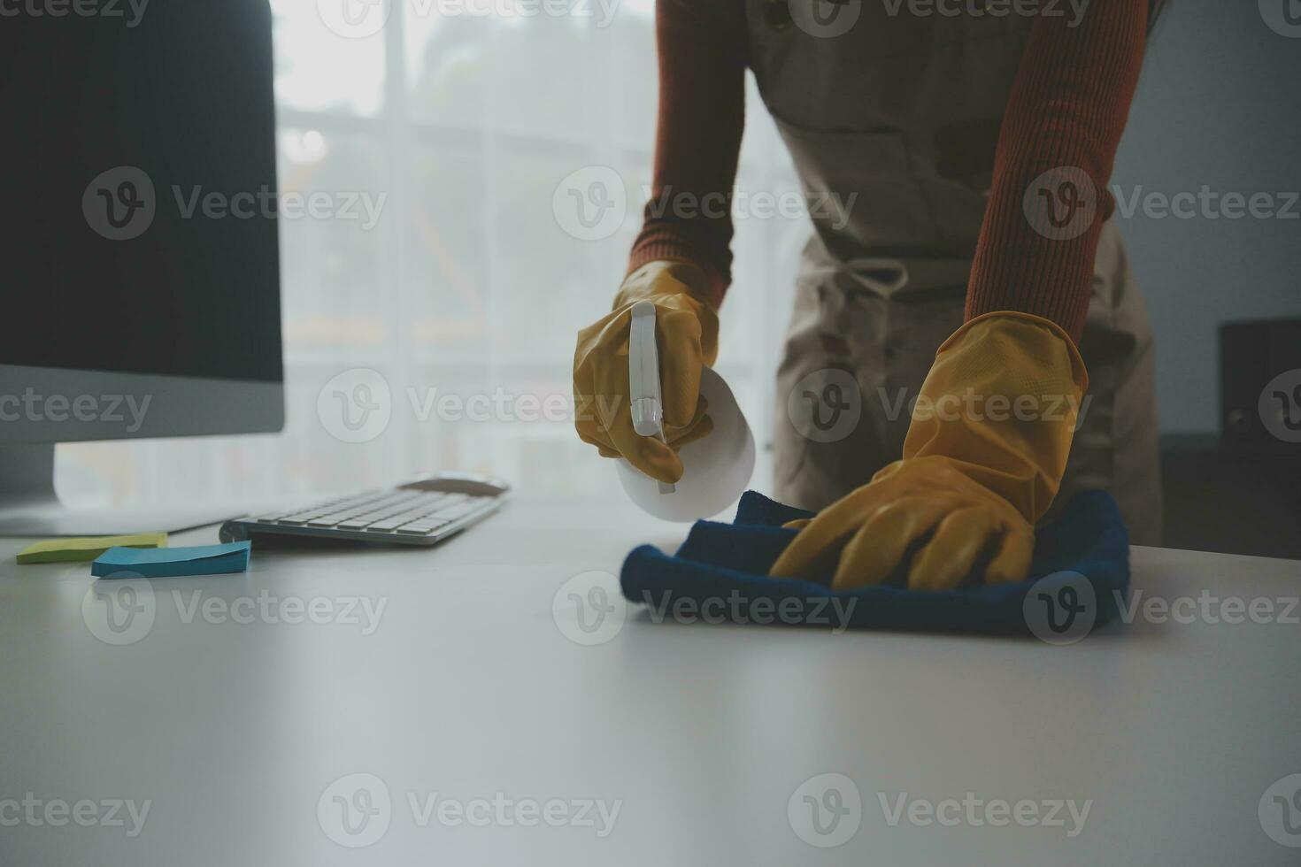 Office Cleaning Service. Janitor Spraying Desk. Workplace Hygiene photo