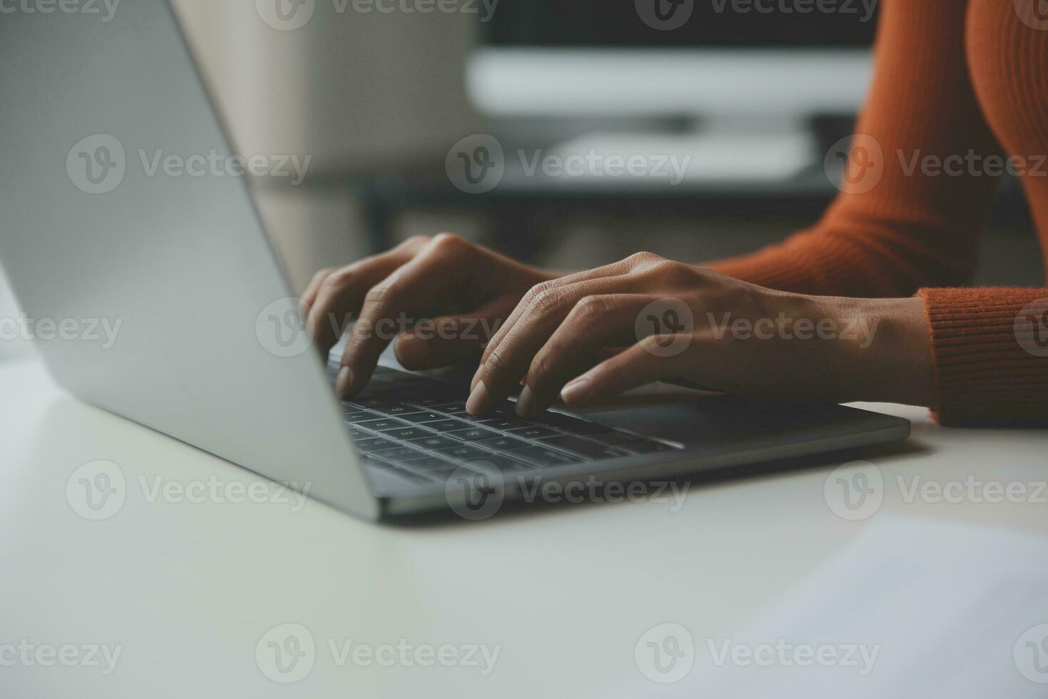 Asian Businesswoman Using laptop computer and working at office with calculator document on desk, doing planning analyzing the financial report, business plan investment, finance analysis concept. photo