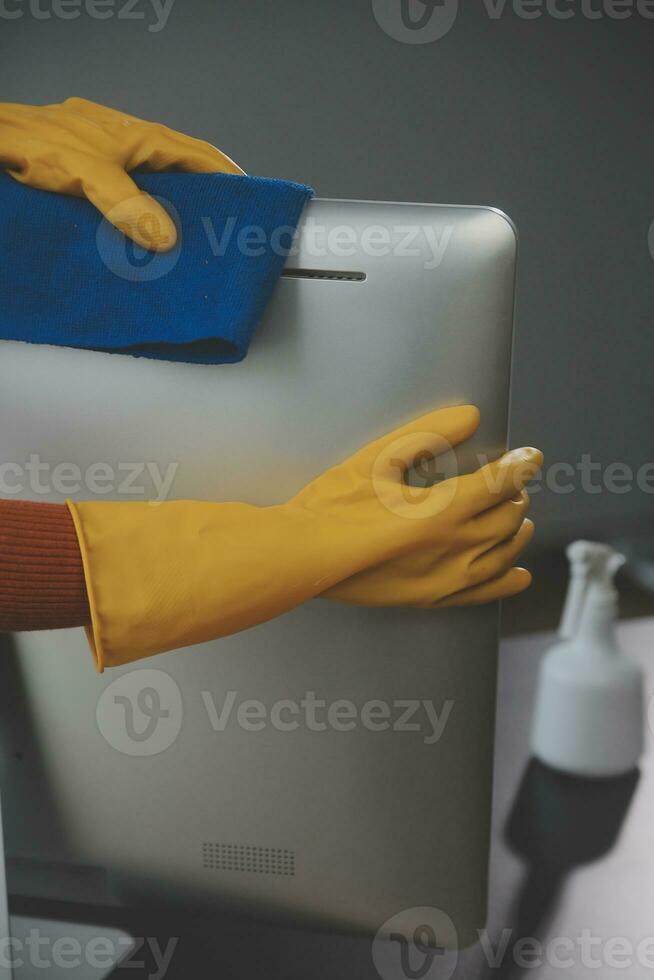 Office Cleaning Service. Janitor Spraying Desk. Workplace Hygiene photo