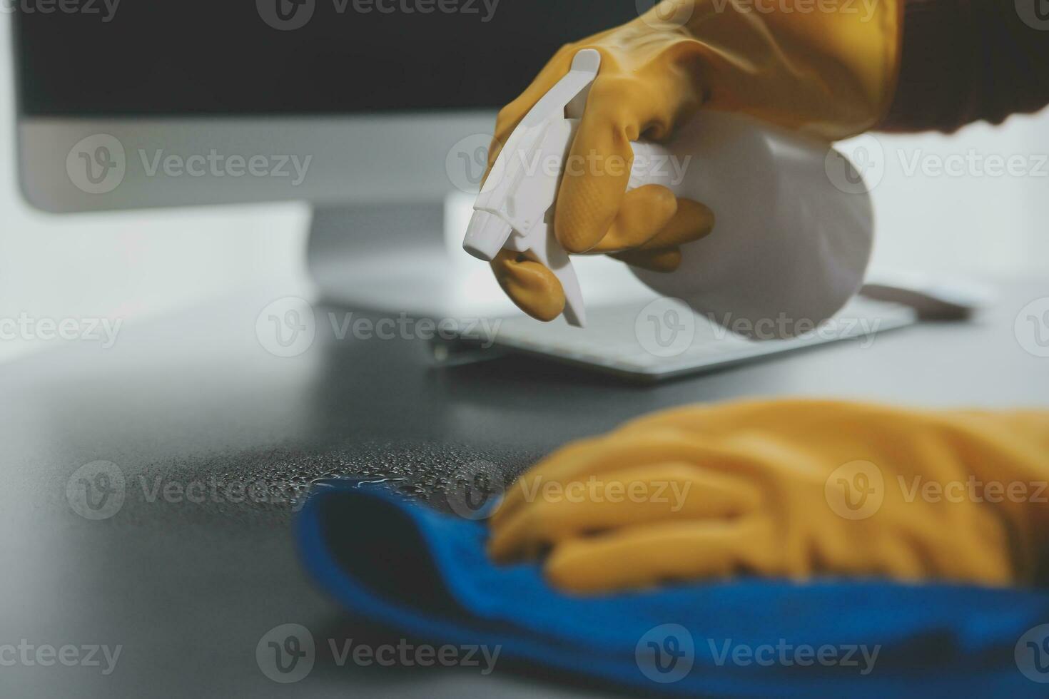 Office Cleaning Service. Janitor Spraying Desk. Workplace Hygiene photo