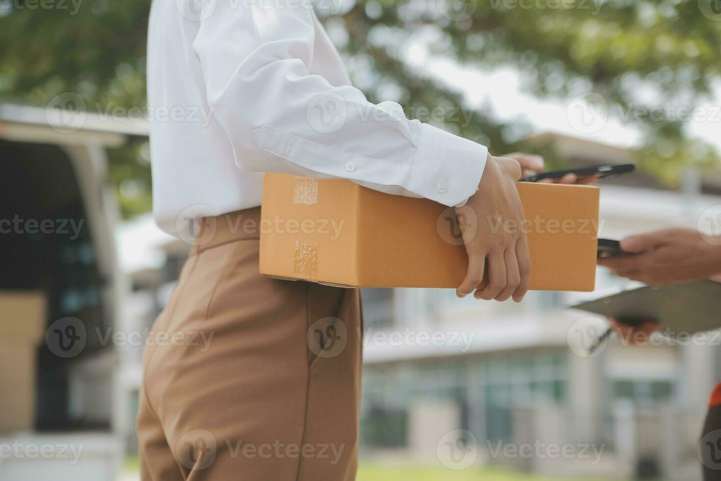 Asian Woman Receiving Product from delivery man at Home, Young Owner Woman Order Product from Smartphone Application, Woman with Online Business or SME Concept. photo