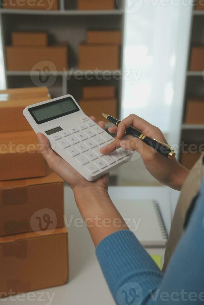 Business woman start up small business entrepreneur SME success .freelance woman working at home with Online Parcel delivery. SME and packaging deliveryconcept photo