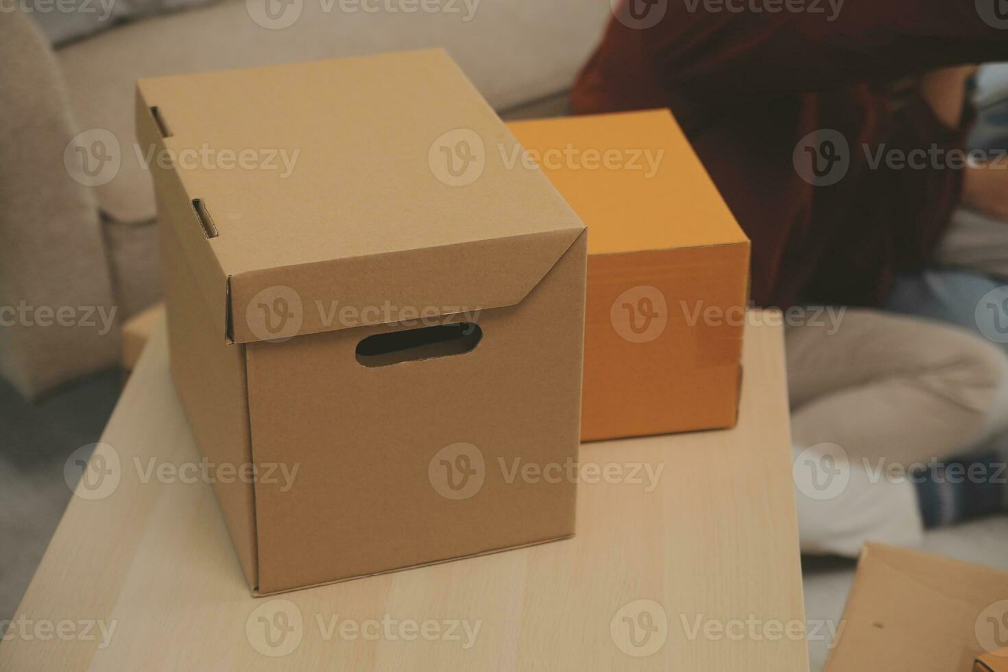 Beautiful young couple in love having fun unpacking things from cardboard boxes while moving in together in their new apartment photo