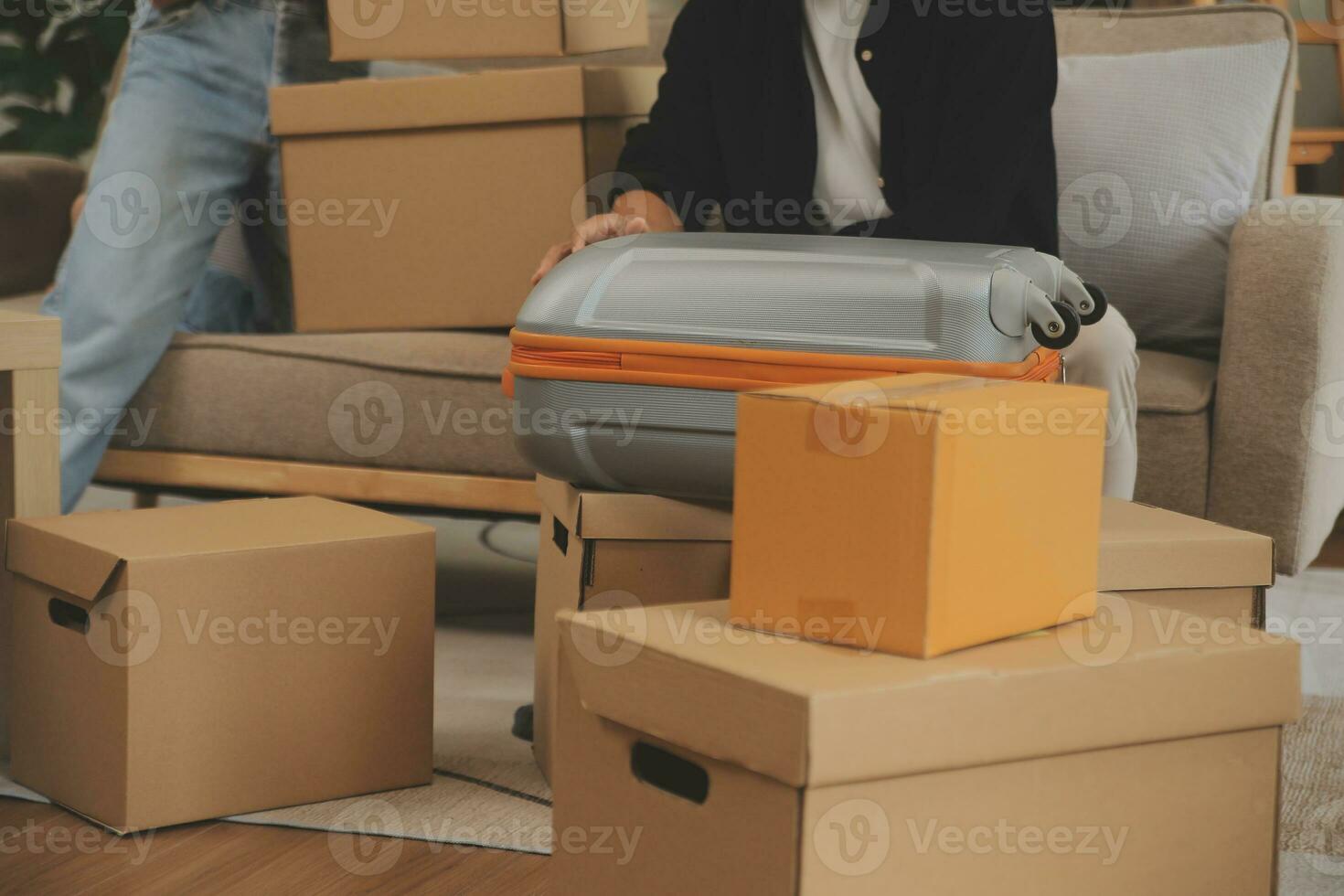 Beautiful young couple in love having fun unpacking things from cardboard boxes while moving in together in their new apartment photo
