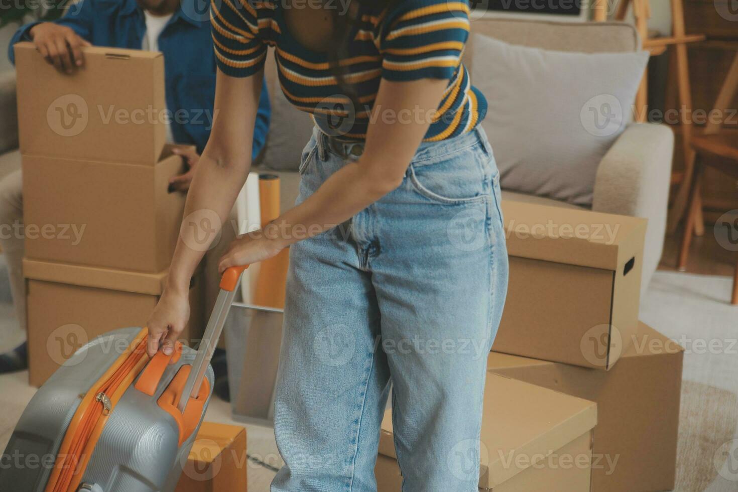Beautiful young couple in love having fun unpacking things from cardboard boxes while moving in together in their new apartment photo