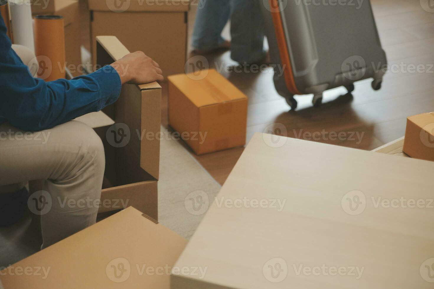 Beautiful young couple in love having fun unpacking things from cardboard boxes while moving in together in their new apartment photo