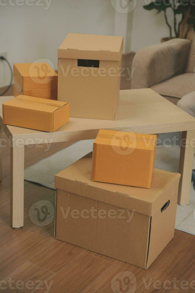 Beautiful young couple in love having fun unpacking things from cardboard boxes while moving in together in their new apartment photo