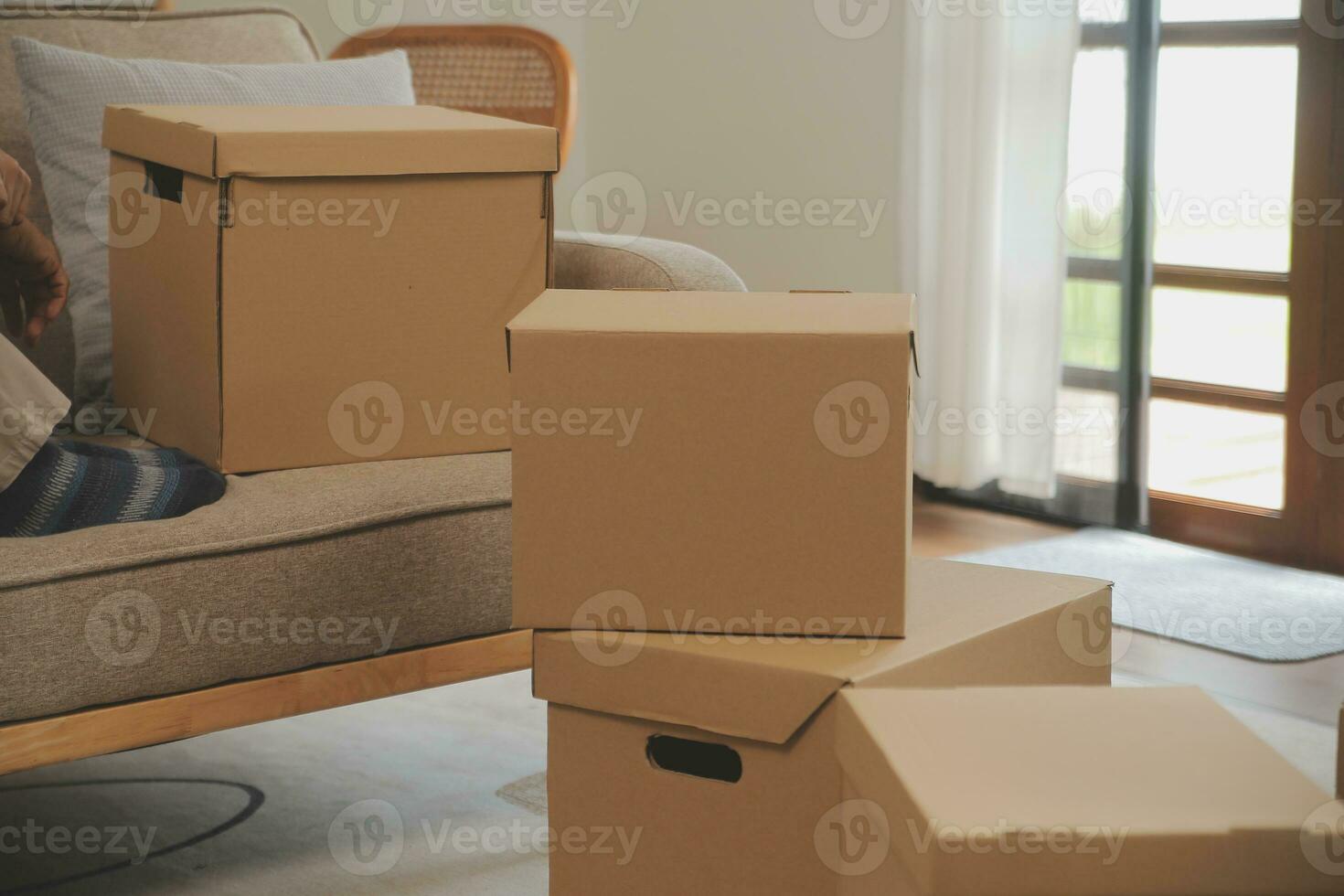 Beautiful young couple in love having fun unpacking things from cardboard boxes while moving in together in their new apartment photo