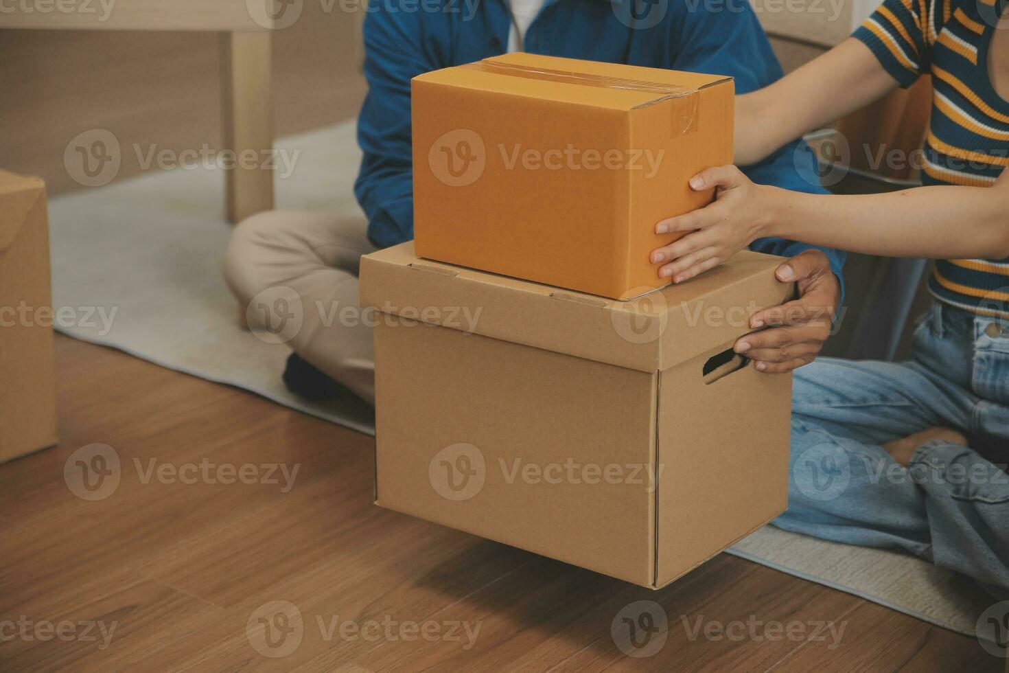 Beautiful young couple in love having fun unpacking things from cardboard boxes while moving in together in their new apartment photo