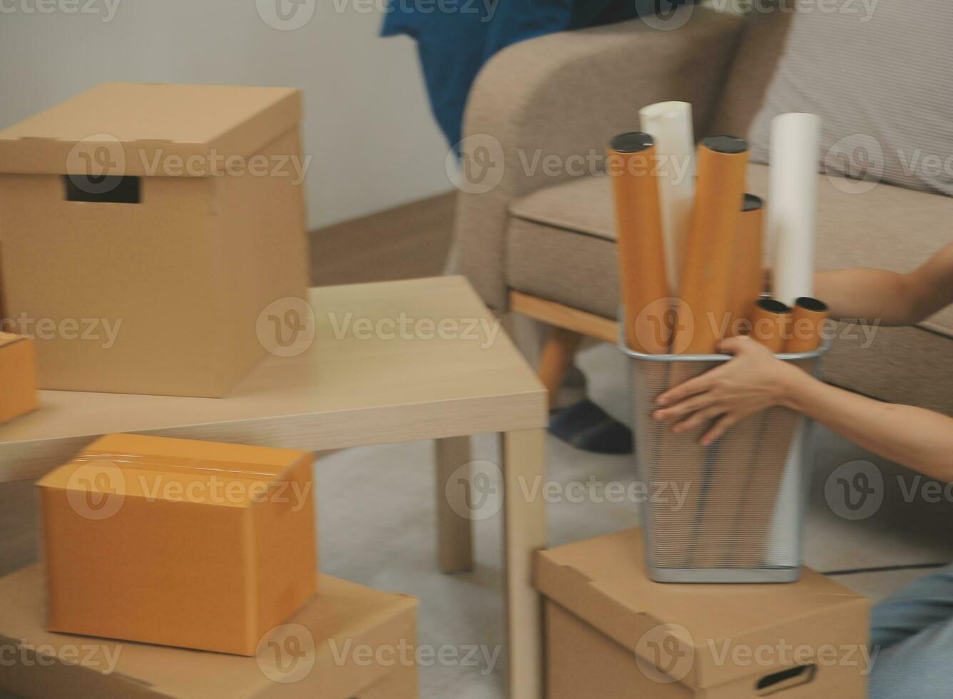 Beautiful young couple in love having fun unpacking things from cardboard boxes while moving in together in their new apartment photo