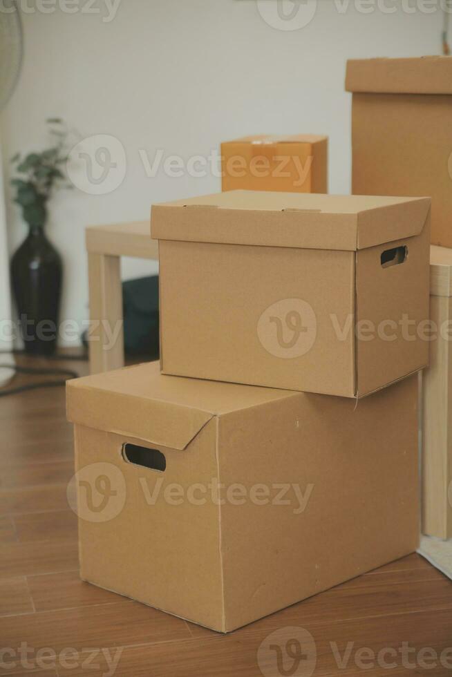 Beautiful young couple in love having fun unpacking things from cardboard boxes while moving in together in their new apartment photo