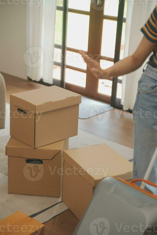 Beautiful young couple in love having fun unpacking things from cardboard boxes while moving in together in their new apartment photo