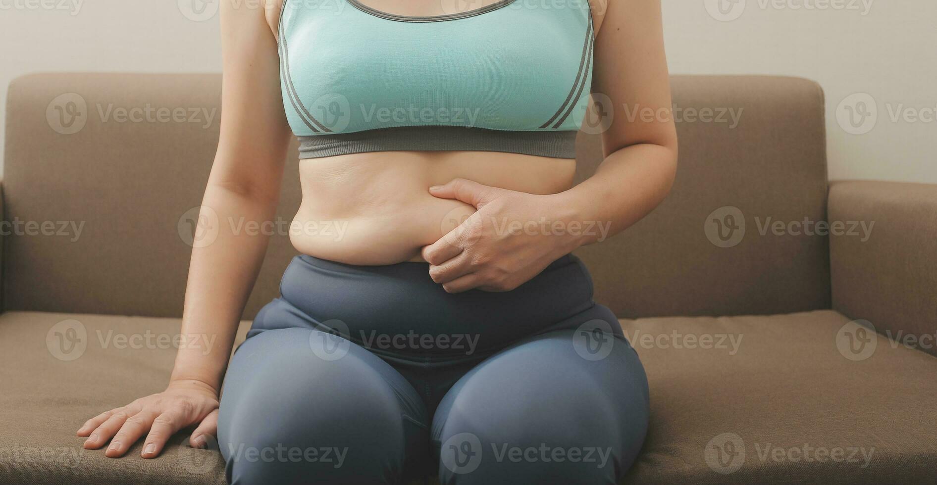 Women body fat belly. Obese woman hand holding excessive belly fat. diet lifestyle concept to reduce belly and shape up healthy stomach muscle. photo