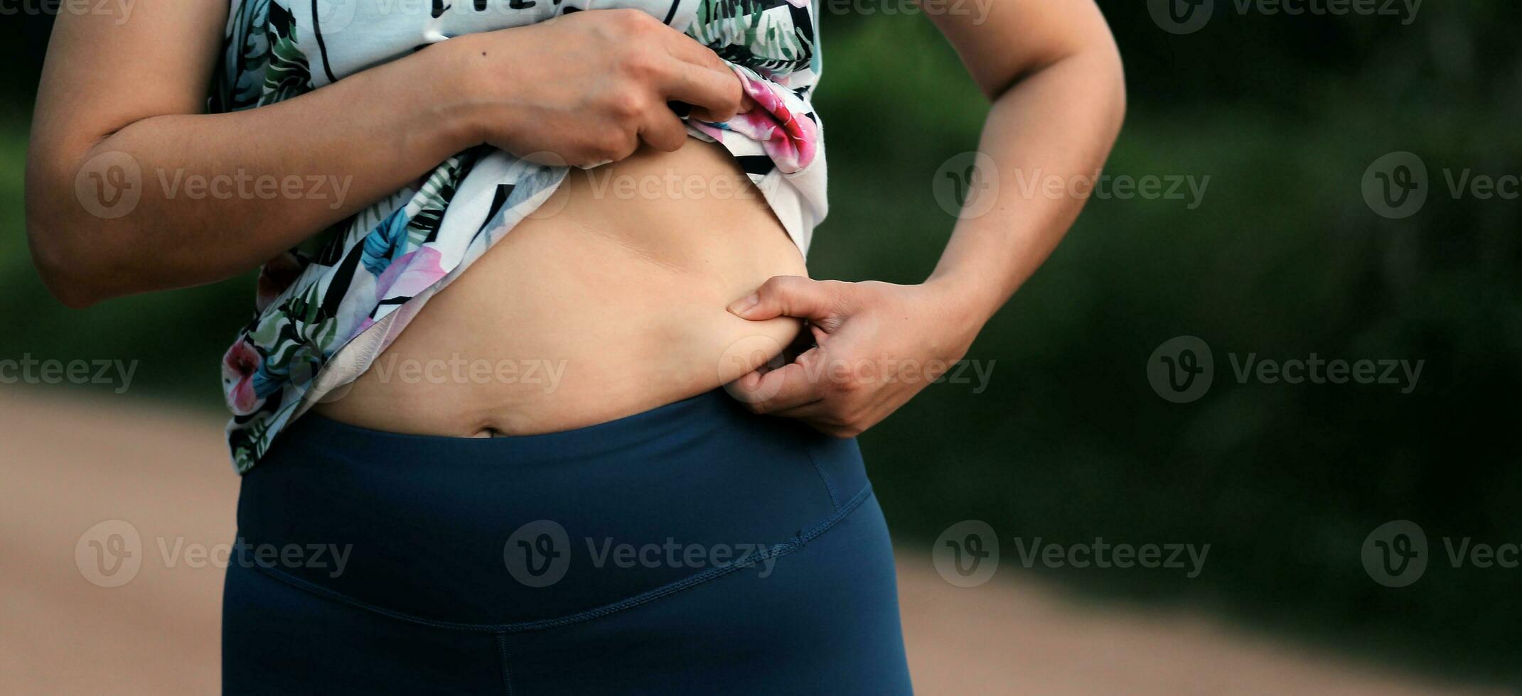 Women body fat belly. Obese woman hand holding excessive belly fat. diet lifestyle concept to reduce belly and shape up healthy stomach muscle. photo