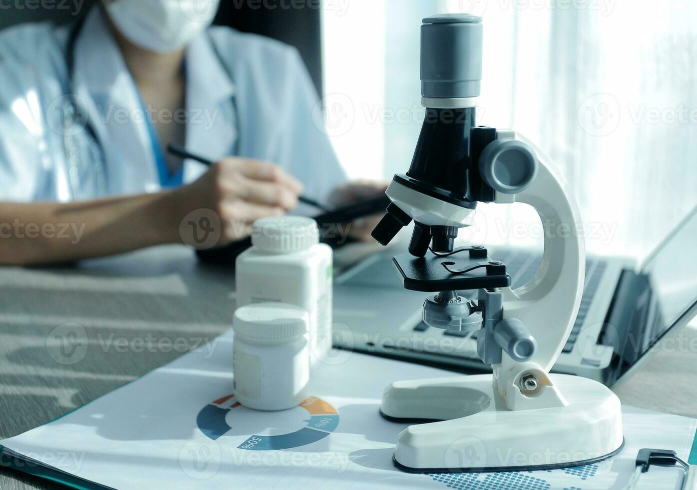 joven científicos conductible investigación investigaciones en un médico laboratorio, un investigador en el primer plano es utilizando un microscopio foto